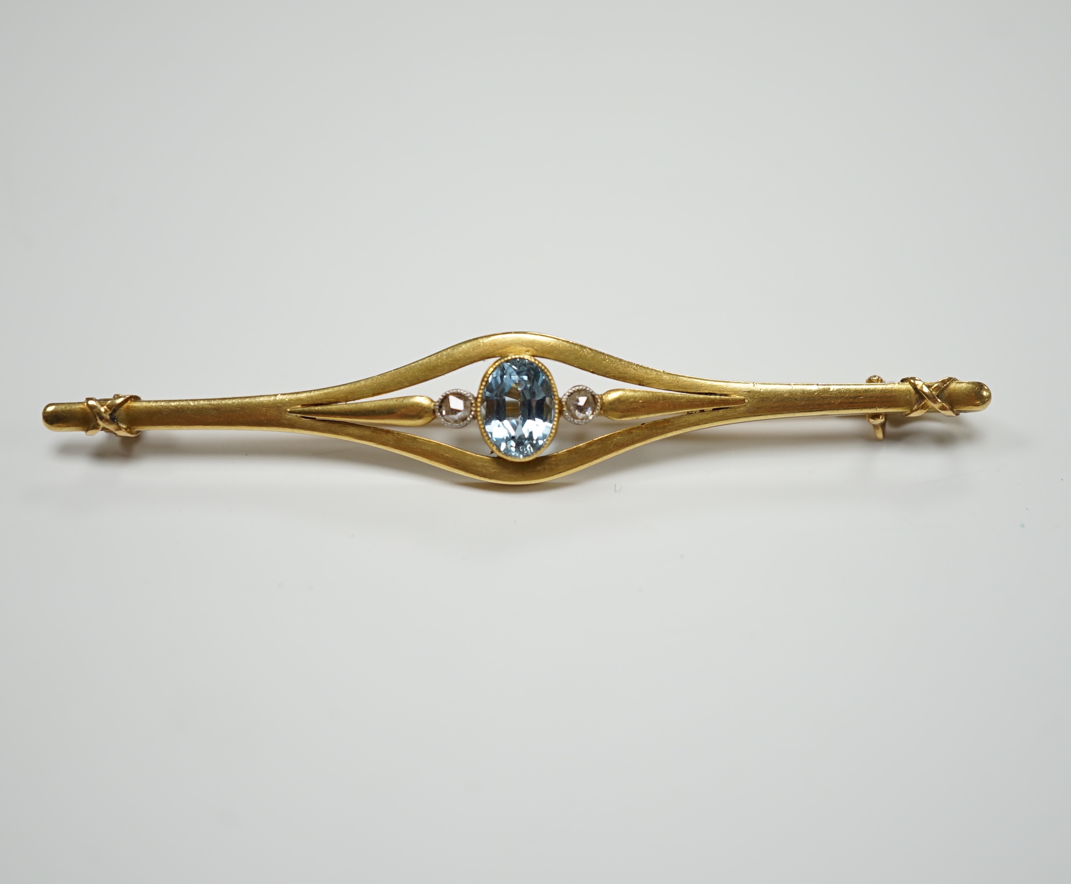 An early 20th century French yellow metal (18ct poincon mark), aquamarine and rose cut diamond set three stone bar brooch, 71mm, gross weight 9.1 grams.